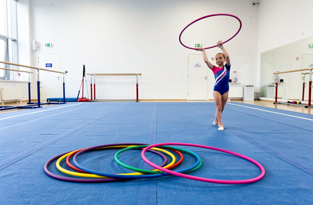 Cerceaux de gymnastique colorés disposés dans une salle d'entraînement lumineuse.